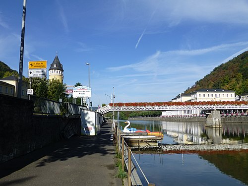 Fun boats and white pedestrian bridge on the Lahn at Bad Ems.