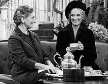 The two actresses seated, having tea