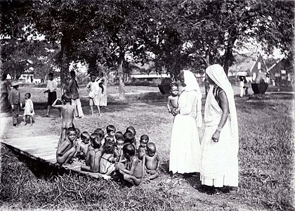 Kinderbewaarplaats met Hindoestaanse kinderen en vrouwen van Brits-Indische afkomst op de suikerplantage Mariënburg in het district Commewijne (ca.1910)