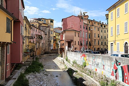 Torrente Carrione, houses along of the river and a nearly empty, concrete Graffiti wall