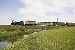 Jokioisten Museorautatien höyryvetoinen museojuna ylittää Jänhijoen rautatiesiltaa