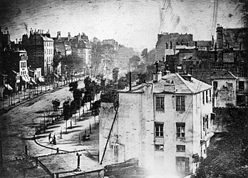 L'un des tout premiers daguerréotypes, réalisé boulevard du Temple, à Paris, en 1838. Cette image est celle d'une rue animée, mais, le temps d'exposition ayant dépassé dix minutes, le trafic était trop rapide pour être fixé sur l'image. Seul apparaît donc l'homme en bas à gauche, qui est resté immobile pour faire cirer ses chaussures. (définition réelle 3 441 × 2 472)