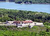 Walled stone fort on top of a green hill overlooking a lake