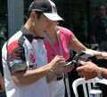 Sato signing a hat