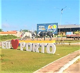 Letral com toponímia e monumento dos touros em praça pública.