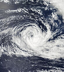 Satellite image of a rather disorganized tropical cyclone, with ragged banding features and a disorganized center of circulation.