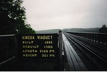 View across the bridge from the bridge deck. A sign indicating the bridge's construction year, reconstruction year, height and length is next to the bridge deck.