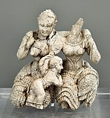 Două femei cu un copil; 1400-1300 î.Hr.; fildeș; înălțime: 7.8 cm; Muzeul Național de Arheologie (Atena)[19]