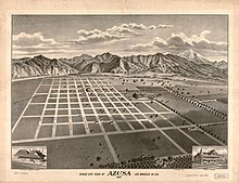 Depiction of town plan, streets are laid out in a grid with a mountain range in the background