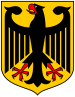 Coat of arms featuring a large black eagle with wings spread and beak open. The eagle is black, with red talons and beak, and is over a gold background.