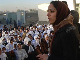 Malalai Joya, one of about 100 women delegates to the constitutional council in Afghanistan, speaks to students in a girl’s school in Farah, Afghanistan. Afghanistan has its first democratically elected government as a result of the U.S., allied, and Northern Alliance military action in 2001 that toppled the Taliban for sheltering Osama bin Laden, mastermind of the September 11, 2001, terrorist attacks against the United States.