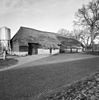 Hoeve onder hoog rieten wolfsdak met stal met twee zijbaanders