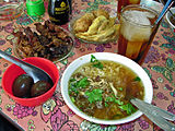 Yon seleksyon kwizin Endonezi, avèk Soto Ayam (chicken soup), sate kerang (shellfish kebabs), telor pindang (preserved eggs), perkedel (fritter), ak es teh manis (sweet iced tea)