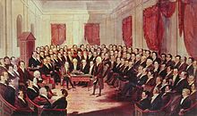 Eine Sitzung des Verfassungskonvents von Virginia 1829–1830. Der alte Madison steht gebeugt zentral während alle anderen Delegierten auf ihn blicken.