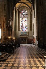 Photographie intérieure d'une église gothique se terminant par une rosace.