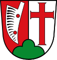 Gemeinde Wollishausen Über grünem Dreiberg gespalten von Rot und Silber; vorne eine auf der Spitze stehende silberne Pflugschar in altertümlicher Form, hinten ein schwebendes rotes Kreuz.