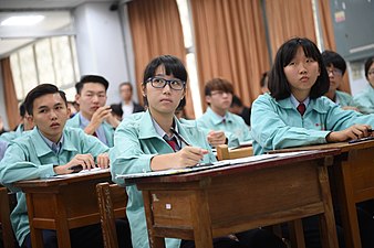 Alumnos taiwaneses de secundaria en su uniforme escolar con batas de color turquesa.