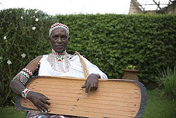 Photo of a trough zither called an Inanga, and its player Torobeka Joseph from Burundi.