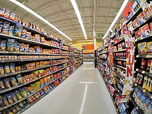 An image displaying a supermarket aisle containing many ultra-processed foods, mainly chips.