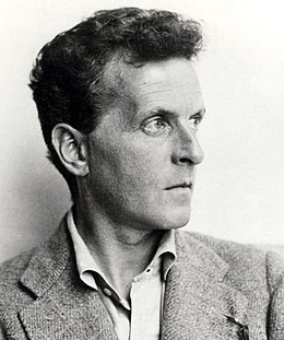 Photographie en noir et blanc d'un homme en veston tourné de trois quarts vers la gauche gauche.
