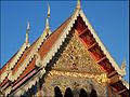 Gable roof with eaves, exposed, decorated rafters and soffits, and stepped ascending apexes, temple in Chiang Mai, Thailand.