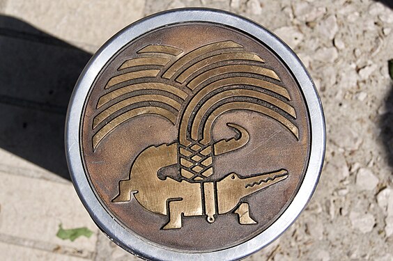 A manhole cover in Nimes showing a stylized crocodile