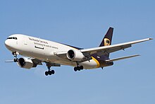 Side quarter view of UPS twin-engine freighter in flight, with extended gear.