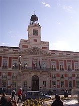 La Real Casa de Correos está en la Puerta del Sol/The Real Casa de Correos (literally "Royal Mail House") is at the Puerta del Sol (square)