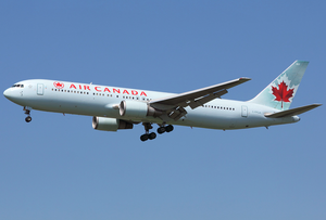 A side/underneath view of a Boeing 767-300 in Delta Air Lines' white, blue, and red color during climbout. The main undercarriage doors are retracting.