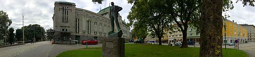 Fasaden mot Christian Michelsens gate med inngangen til «Lille Scene». Roar Bjorgs statue av Nordahl Grieg ble avduket 1957. Foto: Fortegnet panoramabilde, 2015