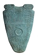 Reverso de la Paleta de Narmer, hacia el 3100 aC. La fila superior representa a cuatro hombres que llevan estándares. Sobre ellos es un Serej que contiene el nombre del rey, Narmer.