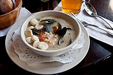 Krim makanan laut gaya krim di sebuah restoran, dihidangkan dengan keropok tiram di dalam mangkuk di sebelah kiri