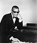 Photo of Ray Charles in one of his classic poses at the piano.