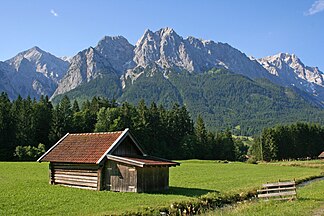Von ganz unten im Tal (bei Grainau). Berge in der Morgensonne von links: Alpspitze, die verschiedenen Waxensteine mit dem Vorgipfel Mandl und ganz im Westen die Zugspitze.
