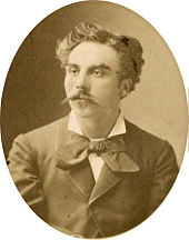 young man in semi profile, with luxuriant moustache and longish dark hair