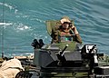 An amphibious assault vehicle operator assigned to the 26th Marine Expeditionary Unit peers out as he prepares to embark aboard the amphibious dock landing ship USS Carter Hall (LSD 50).