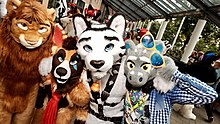 Das Foto zeigt eine Gruppe von vier Personen in Tierkostümen bzw. Fursuits, die alle in die Kamera blicken.