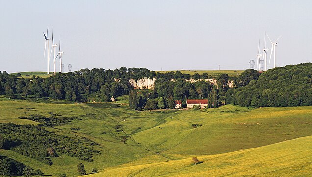 Ferme de la Roche d'Hys, au pied des falaises de calcaire, et éoliennes de Poroy vus de la côte de Vesvres.