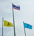 Two royal flags flown along the flag of Thailand.