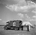 An injured or sick person on a stretcher is loaded into an Austin K2/Y ambulance at a repatriation center in Eindhoven, the Netherlands, 1945.