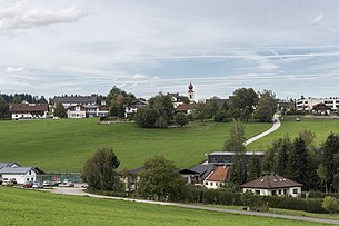 Ansicht vom Haushamerfeld-Denkmal. Links unten die Dorfhalle. Schräg rechts darüber das Gemeindeamt mit Feuerwehr. Mittig oben Kirche mit altem Pfarrhof. Rechts oben das Altersheim.