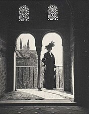 Femme en noir devant les arches d´une mosquée, (vers 1900)