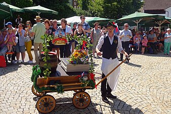 Auf dem Leiterwagen werden Bier und Bierkrüge transportiert.