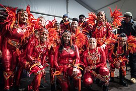Carnival dancers in red feathered costumes posing for photo. The Awakening. LEEDS 2023.jpg