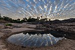 Thumbnail for File:Water reflection of stringy gray and white clouds in a pond on a sand beach of Don Khon at sunrise in Laos.jpg