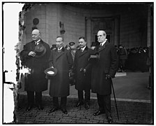 photo d'un groupe de quatre hommes debout en costume.