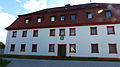 Caritas-Wohnheim St. Ludmilla mit Seitengebäude, Torbogen und Umfassungsmauer mit Steinkreuz