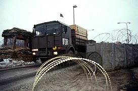 An Austrian Army transport truck trailer unit drives through military checkpoint hauling wood boards for use in humanitarian rebuilding efforts in Bosnia-Herzegovina. The Austrians - DPLA - aae67c0146924bb4679975d47ebe5f64.jpeg