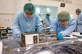 Students and workers wrap new CubeSats in SSPF.jpg