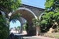 Photographie en couleur d'un viaduc sous lequel passe une route.